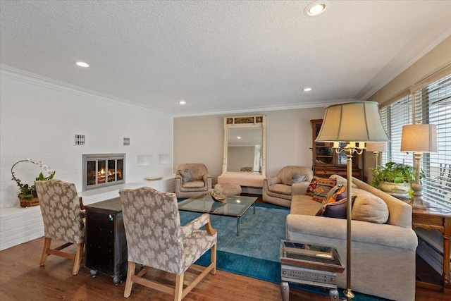 living room featuring ornamental molding, a glass covered fireplace, and wood finished floors