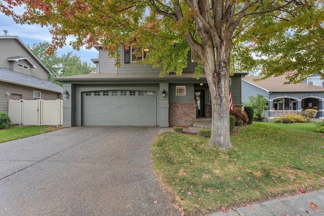 view of front of home with brick siding, fence, concrete driveway, a gate, and a front lawn