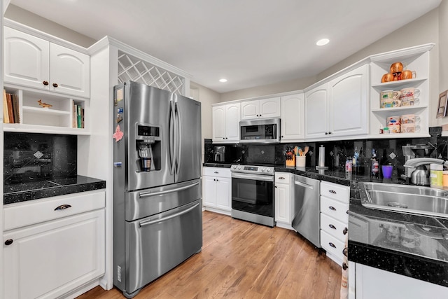 kitchen with stainless steel appliances, light wood-style floors, open shelves, and white cabinets