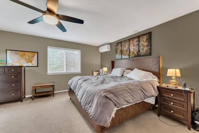 bedroom with a ceiling fan, a wall mounted air conditioner, light colored carpet, and baseboards