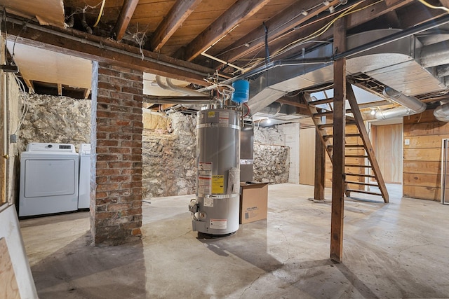 unfinished below grade area featuring strapped water heater, stairs, and washer and clothes dryer