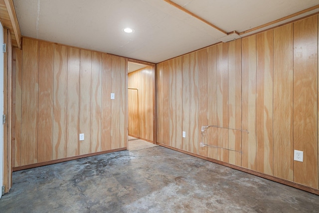 spare room with unfinished concrete floors and wooden walls