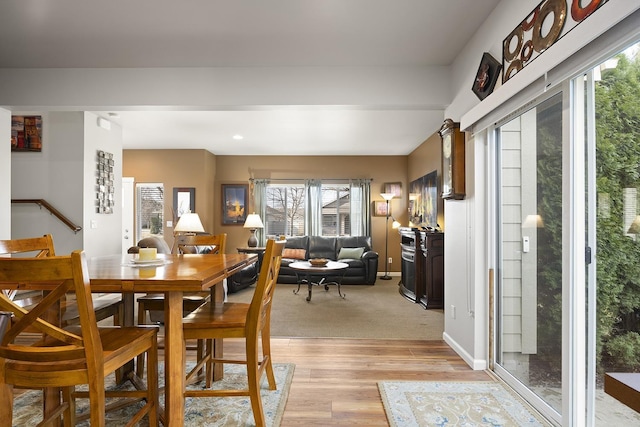 dining space with light wood-style flooring and baseboards