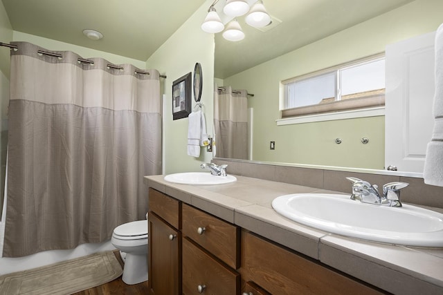 bathroom with shower / bath combo with shower curtain, a sink, toilet, and double vanity