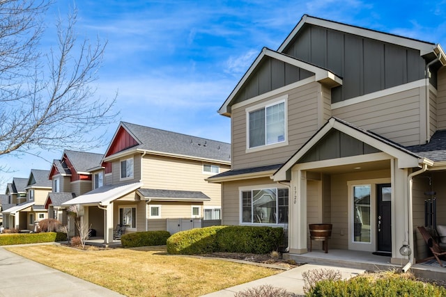 view of front of property with board and batten siding, a porch, and a front lawn