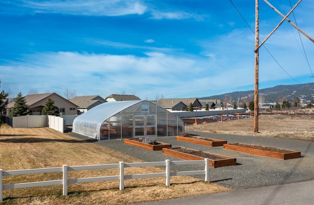 exterior space with an outbuilding, an exterior structure, fence, a mountain view, and a garden