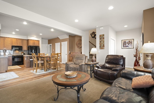 living room with light wood-style floors, recessed lighting, and baseboards