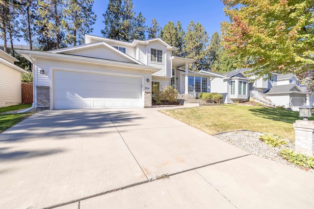 view of front of house with concrete driveway, an attached garage, and a front yard