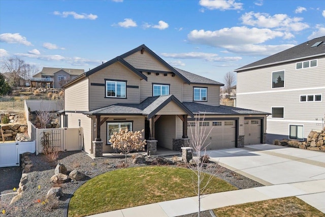 view of front of property featuring a garage, concrete driveway, stone siding, and fence