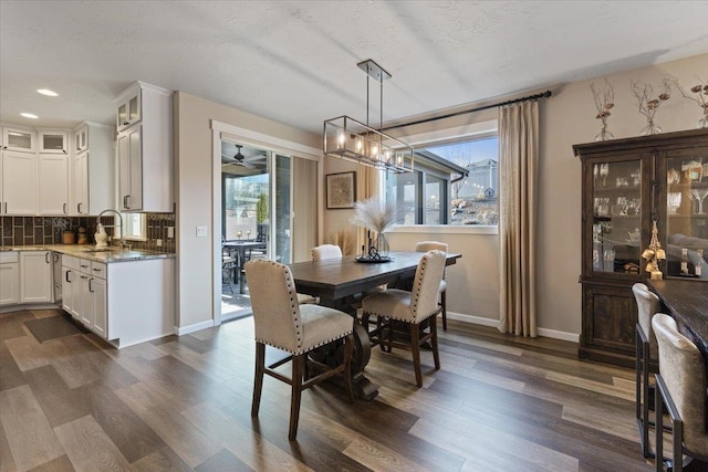 dining area featuring dark wood-type flooring, recessed lighting, a wealth of natural light, and baseboards