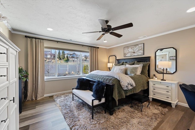 bedroom with visible vents, crown molding, baseboards, and wood finished floors