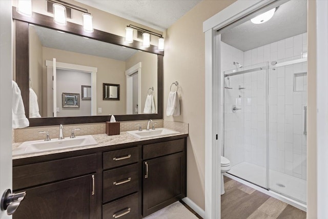 full bath with a stall shower, a sink, and toilet