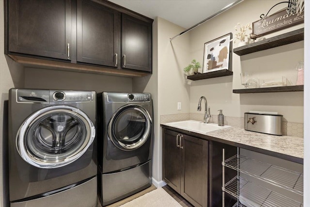 laundry room featuring washer and clothes dryer, a sink, and cabinet space