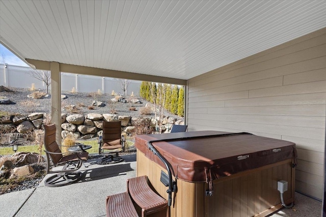 view of patio / terrace featuring fence and a hot tub