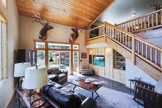 living area featuring high vaulted ceiling, stairway, wooden ceiling, and baseboards