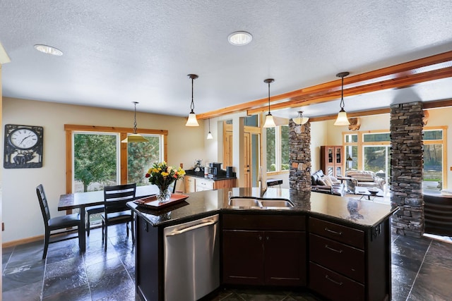 kitchen featuring decorative columns, a textured ceiling, stainless steel dishwasher, and stone tile floors