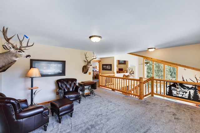 sitting room featuring carpet and an upstairs landing