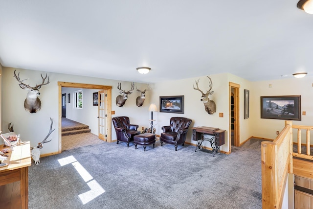 sitting room featuring stairway, baseboards, and carpet flooring