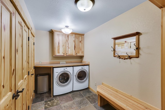 laundry room with cabinet space, washing machine and dryer, baseboards, and stone finish flooring