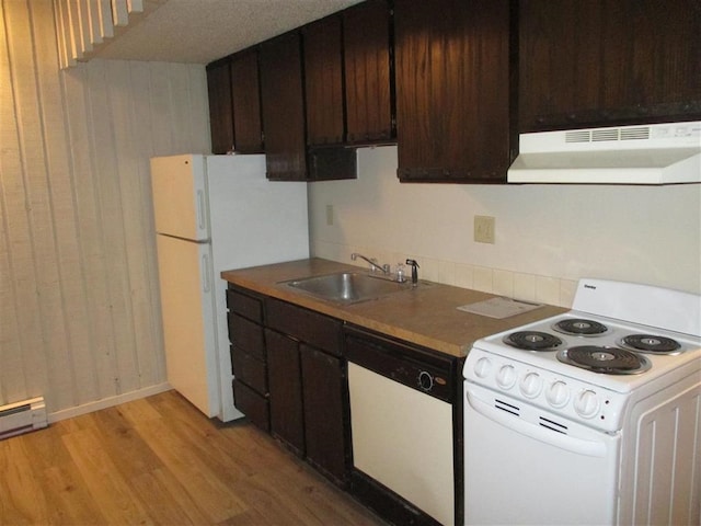 kitchen featuring dark brown cabinetry, white appliances, light wood-type flooring, under cabinet range hood, and a sink