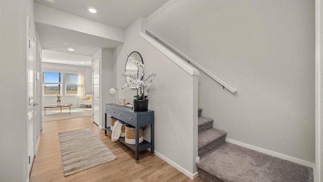 stairway featuring baseboards, wood finished floors, and recessed lighting