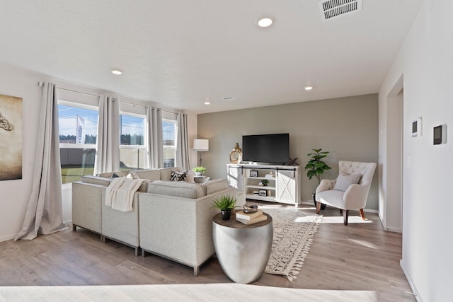 living room with baseboards, recessed lighting, visible vents, and light wood-type flooring