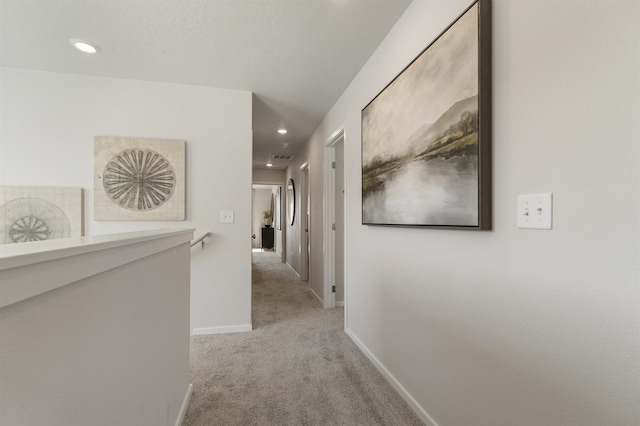 hallway featuring an upstairs landing, recessed lighting, light carpet, and baseboards