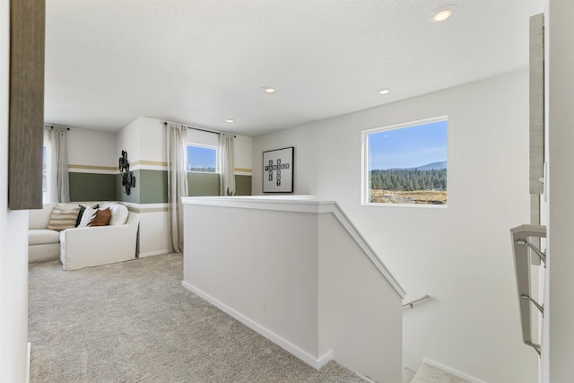 hallway with carpet, baseboards, an upstairs landing, and recessed lighting