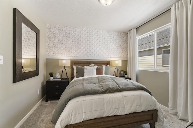 carpeted bedroom featuring wallpapered walls, baseboards, and a textured ceiling