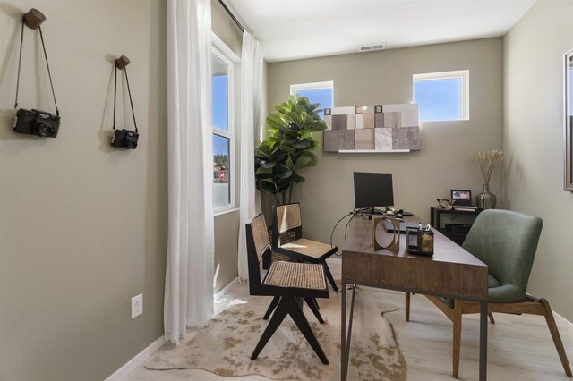 office featuring baseboards, visible vents, and wood finished floors