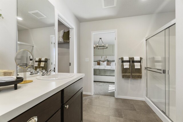 ensuite bathroom featuring vanity, a shower stall, visible vents, and connected bathroom