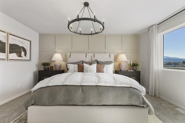 bedroom with light colored carpet, a decorative wall, visible vents, and an inviting chandelier