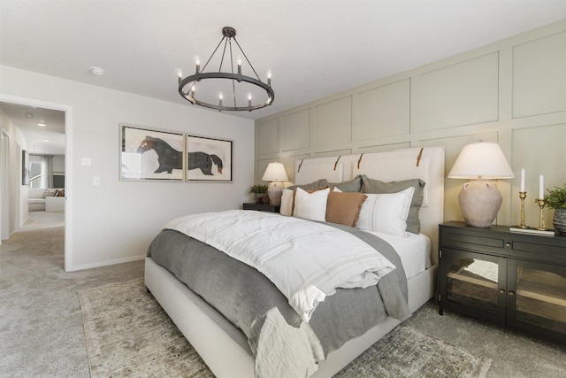 bedroom featuring light carpet, baseboards, a chandelier, and a decorative wall