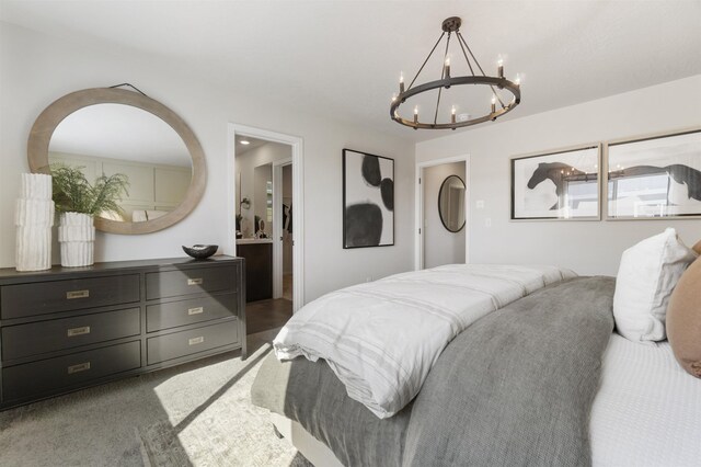 carpeted bedroom featuring ensuite bath and a notable chandelier