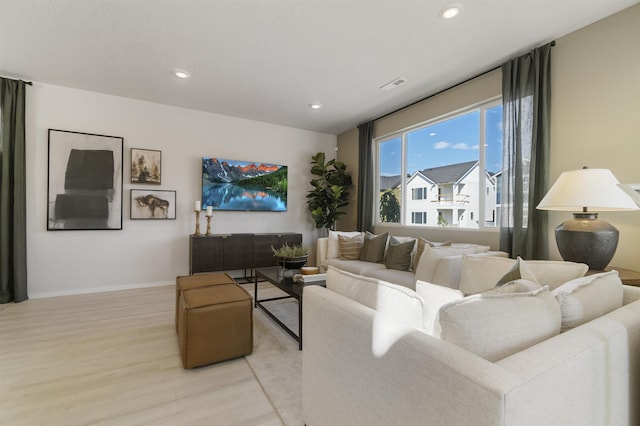 living room with light wood-style floors, baseboards, visible vents, and recessed lighting