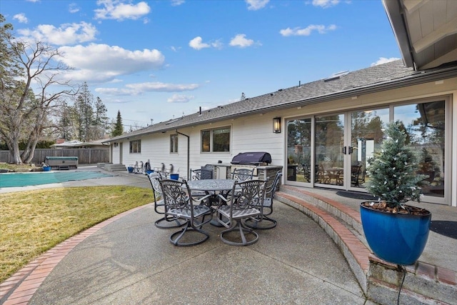 view of patio / terrace with outdoor dining space, grilling area, fence, and a fenced in pool