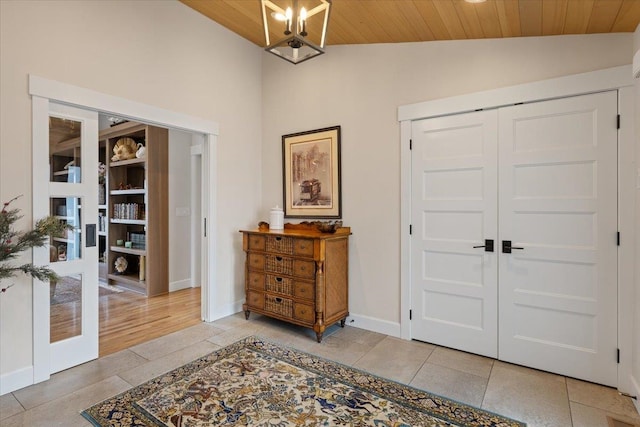 foyer featuring wood ceiling, baseboards, vaulted ceiling, and light tile patterned flooring