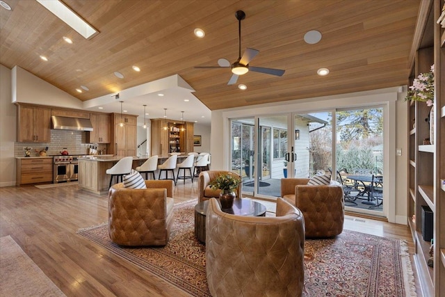 living area featuring vaulted ceiling with skylight, wooden ceiling, and light wood-style floors