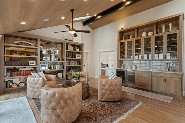 living area with beverage cooler, a ceiling fan, wood ceiling, and light wood-style floors