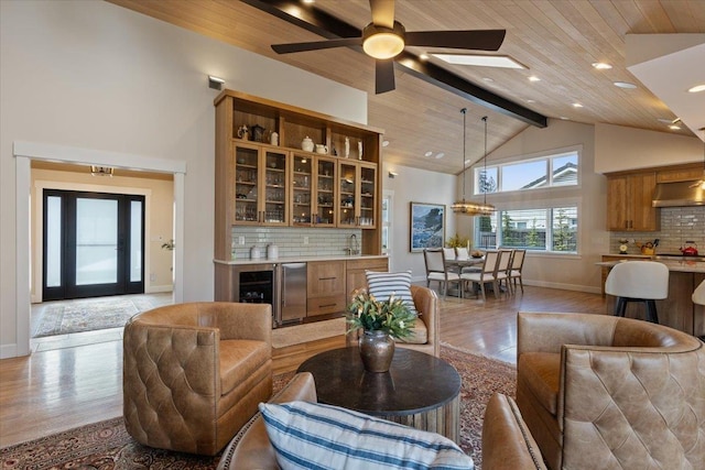 living room with high vaulted ceiling, wooden ceiling, light wood-style flooring, beverage cooler, and baseboards