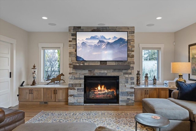 living area featuring a healthy amount of sunlight, visible vents, and wood finished floors