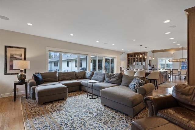 living area with light wood-style floors, baseboards, and recessed lighting