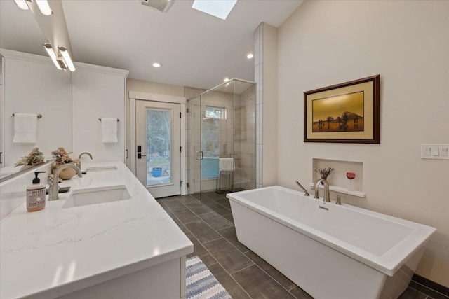 bathroom featuring double vanity, a stall shower, a soaking tub, and a sink