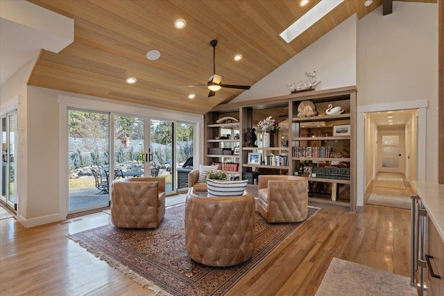 sitting room with high vaulted ceiling, a skylight, wood ceiling, and wood finished floors