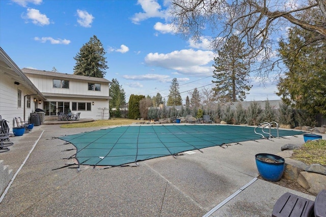 view of pool featuring a covered pool, fence, area for grilling, and a patio