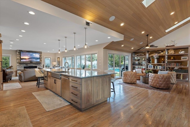 kitchen with open floor plan, a fireplace, a sink, and a kitchen breakfast bar