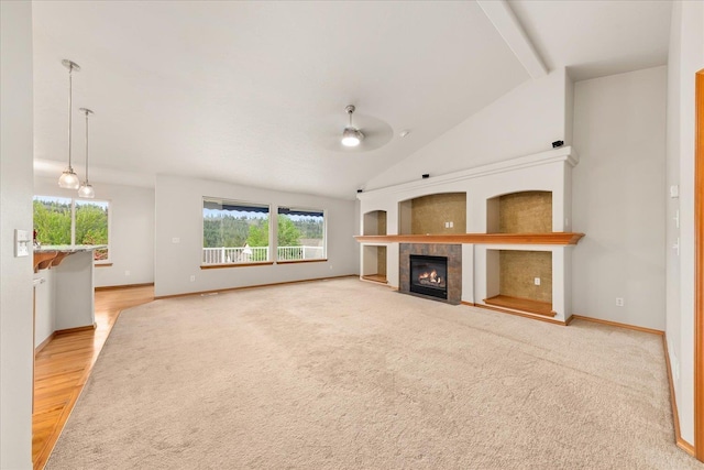 711 W Bolan Ave, Spokane, WA 99224 - unfurnished living room featuring vaulted ceiling, a tiled fireplace, baseboards, a ceiling fan, and light wood-style floors