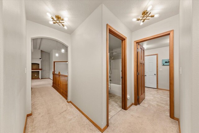 711 W Bolan Ave, Spokane, WA 99224 - hallway with light carpet, arched walkways, and baseboards
