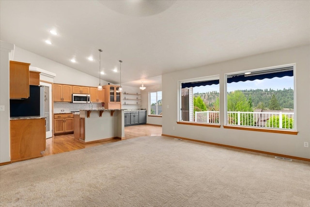 711 W Bolan Ave, Spokane, WA 99224 - kitchen featuring a kitchen bar, light colored carpet, open floor plan, a center island, and light countertops