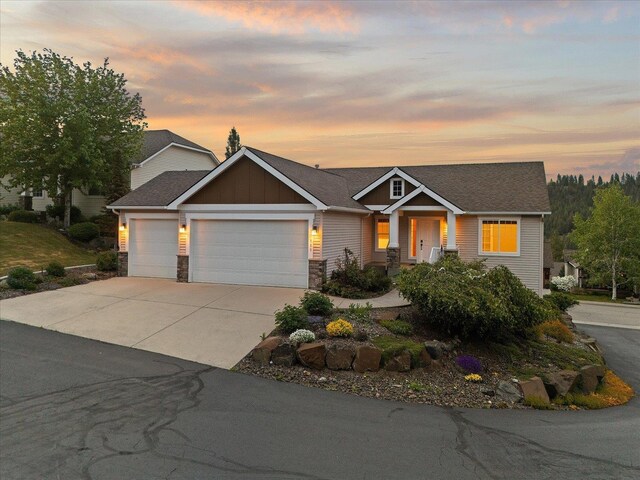 711 W Bolan Ave, Spokane, WA 99224 - craftsman-style home featuring a garage, concrete driveway, stone siding, and board and batten siding